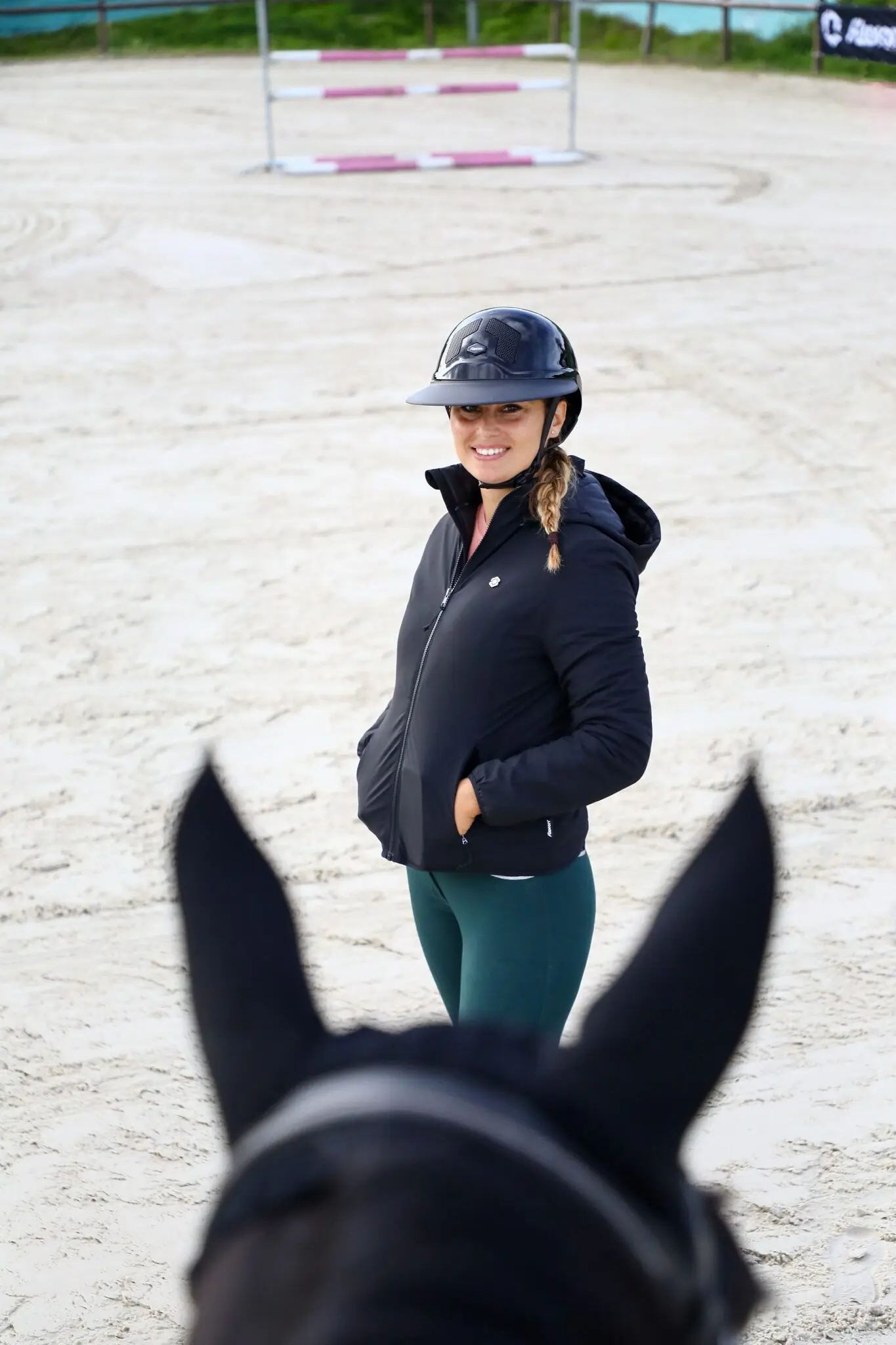 Reiterin mit Helm am Reitplatz
