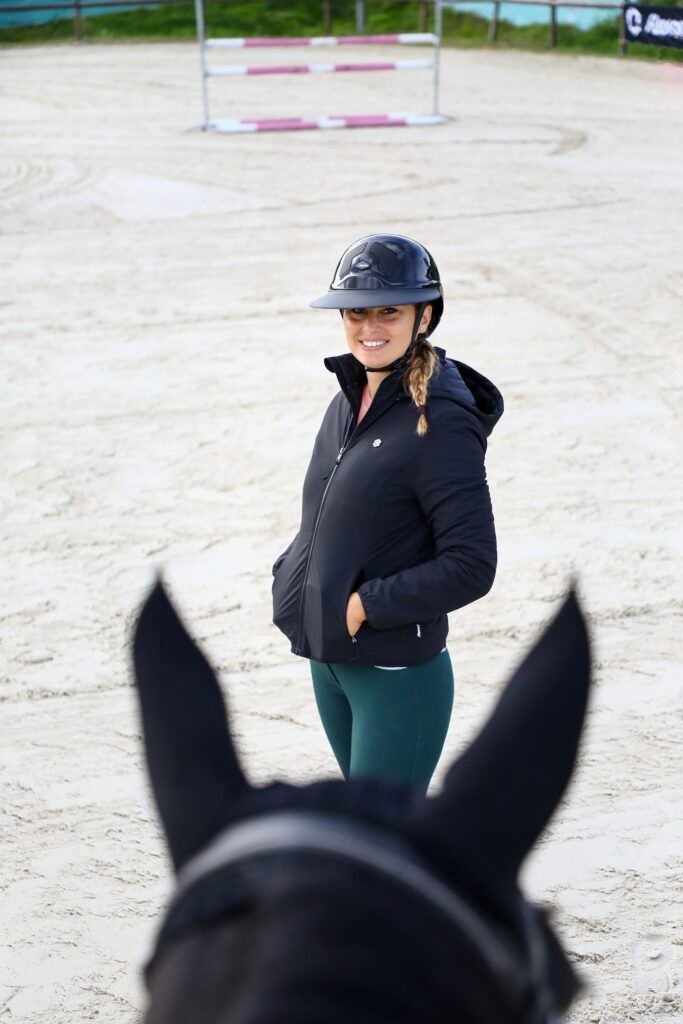 Reiterin mit Helm am Reitplatz