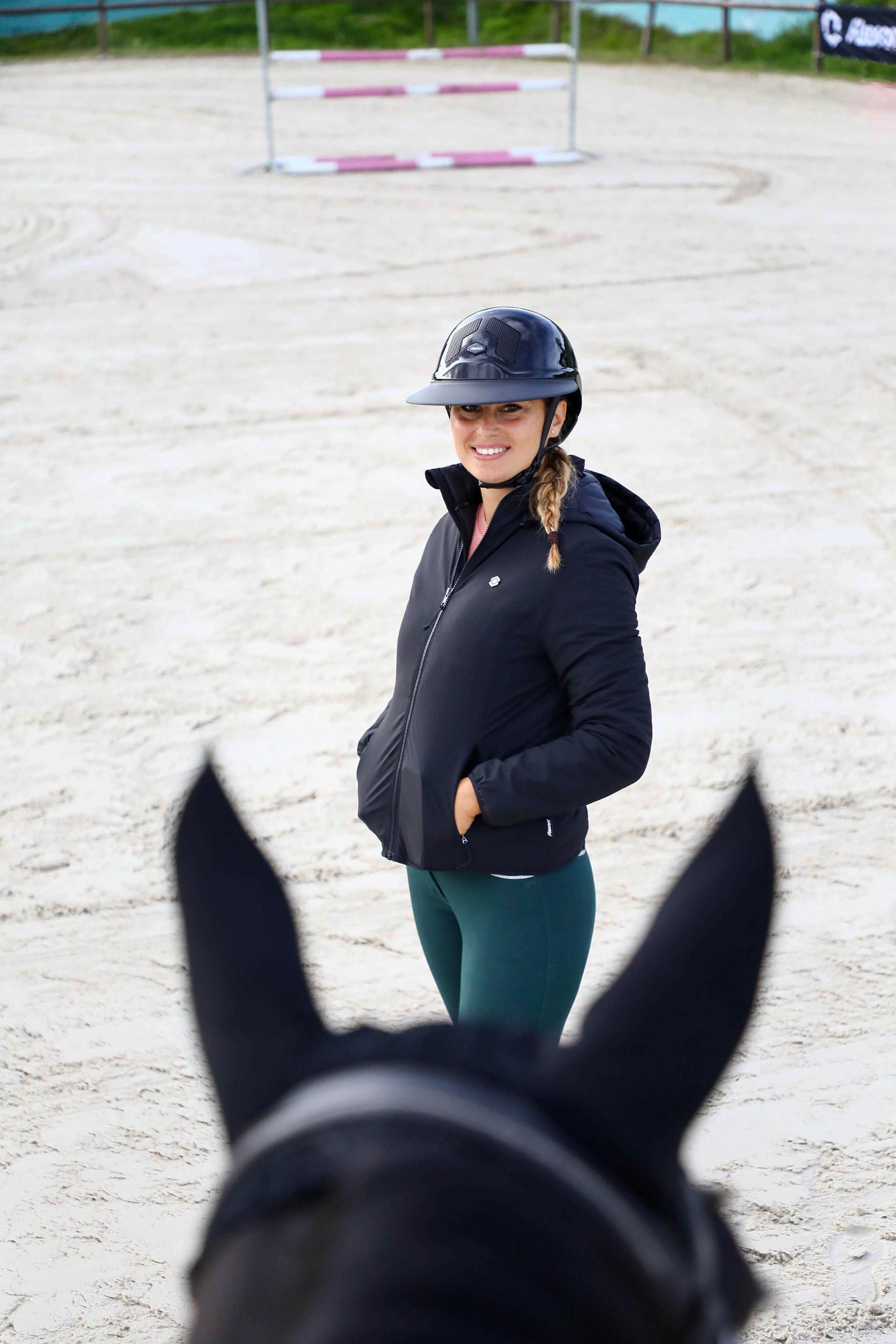 Reiterin mit Helm am Reitplatz
