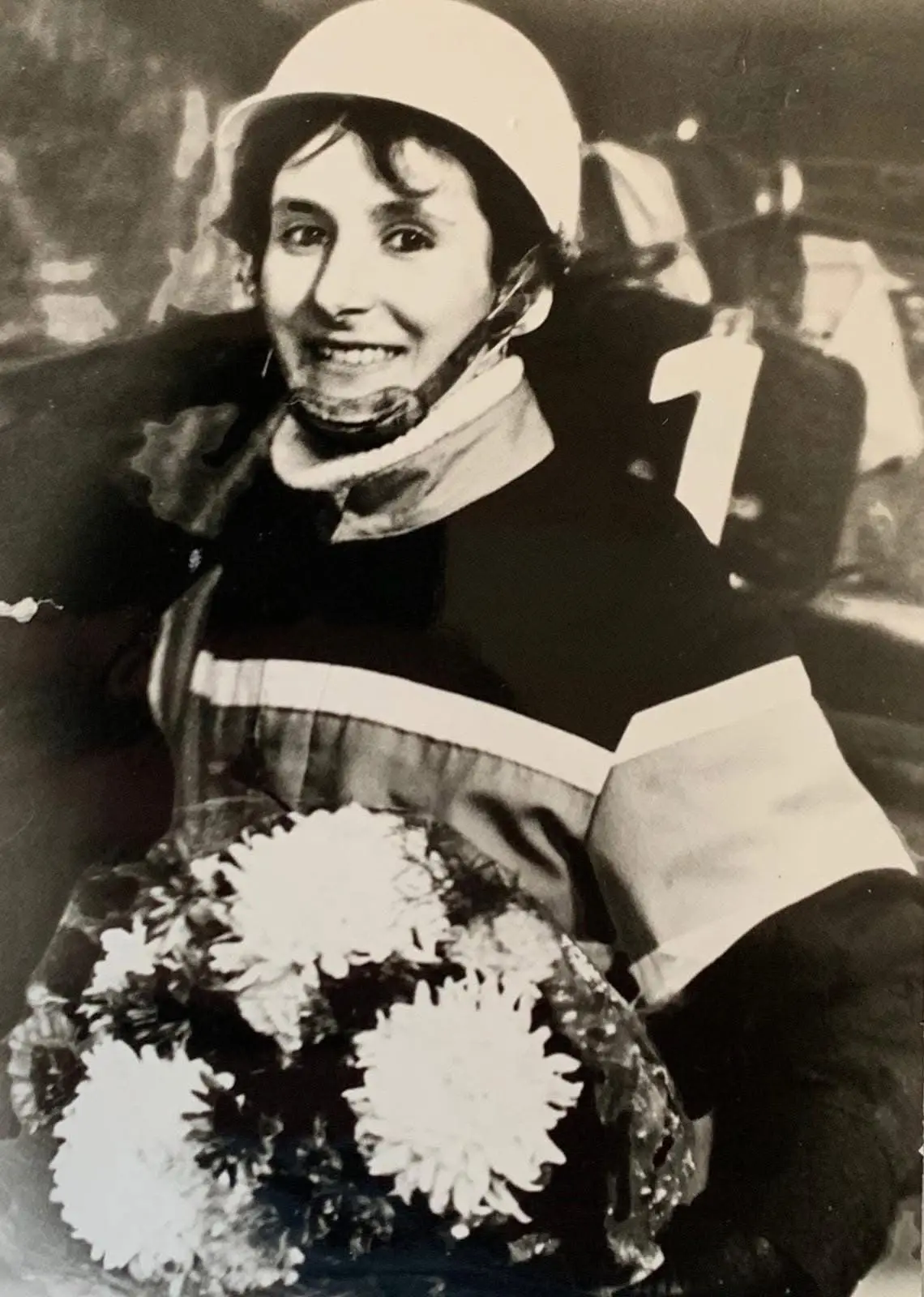 Heike Skowronek in Rennkleidung mit Helm und Blumenstrauß auf einer historischen Familienaufnahme